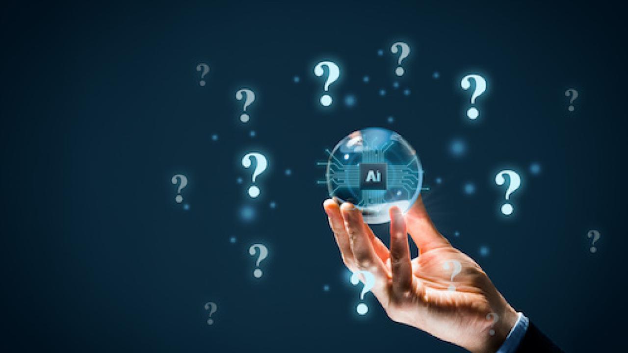 A hand holding a clear ball with "AI" and surrounding "?"s digitally imposed, on a dark background.