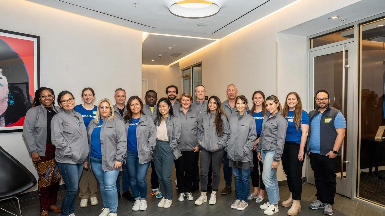 group of people posing for group picture with gray jackets on