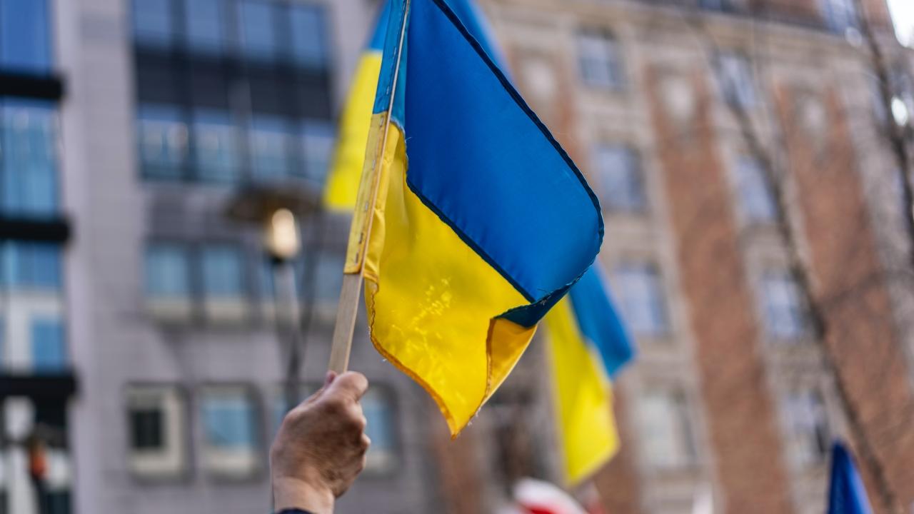 Hand waving a Ukrainian flag at a peace protest.