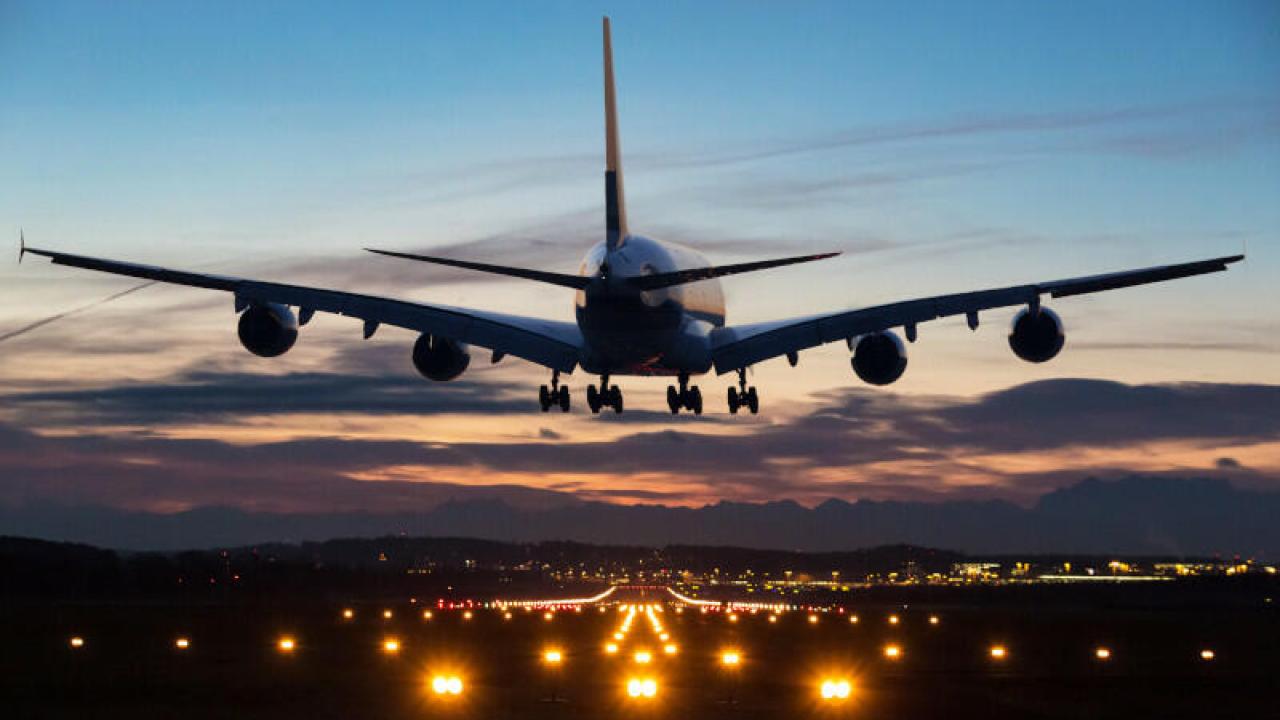 A jet landing on a lighted runway at dusk