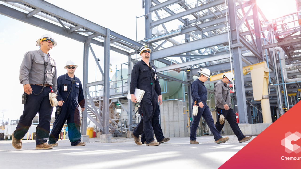 Workers in hardhats walking outside at a plant