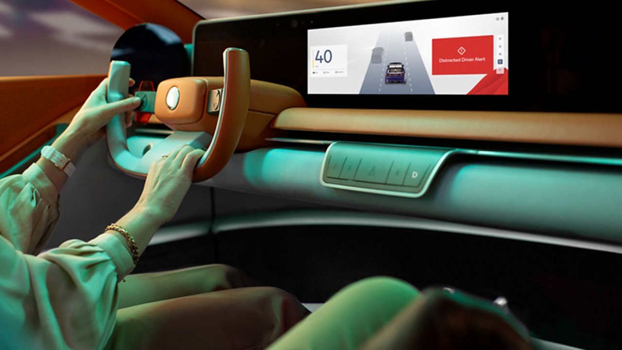 Person driving a car with a screen on the dashboard
