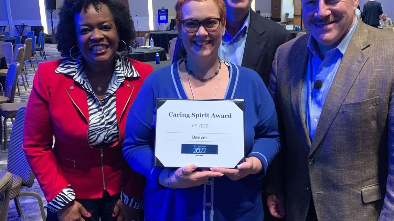 Four employees posing with Caring Spirit Award