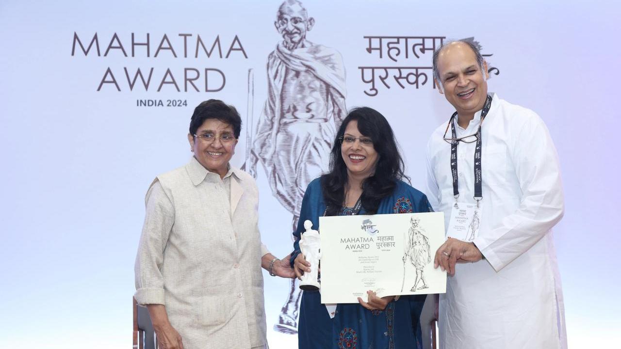 Kavita Sah and two others holding an award.