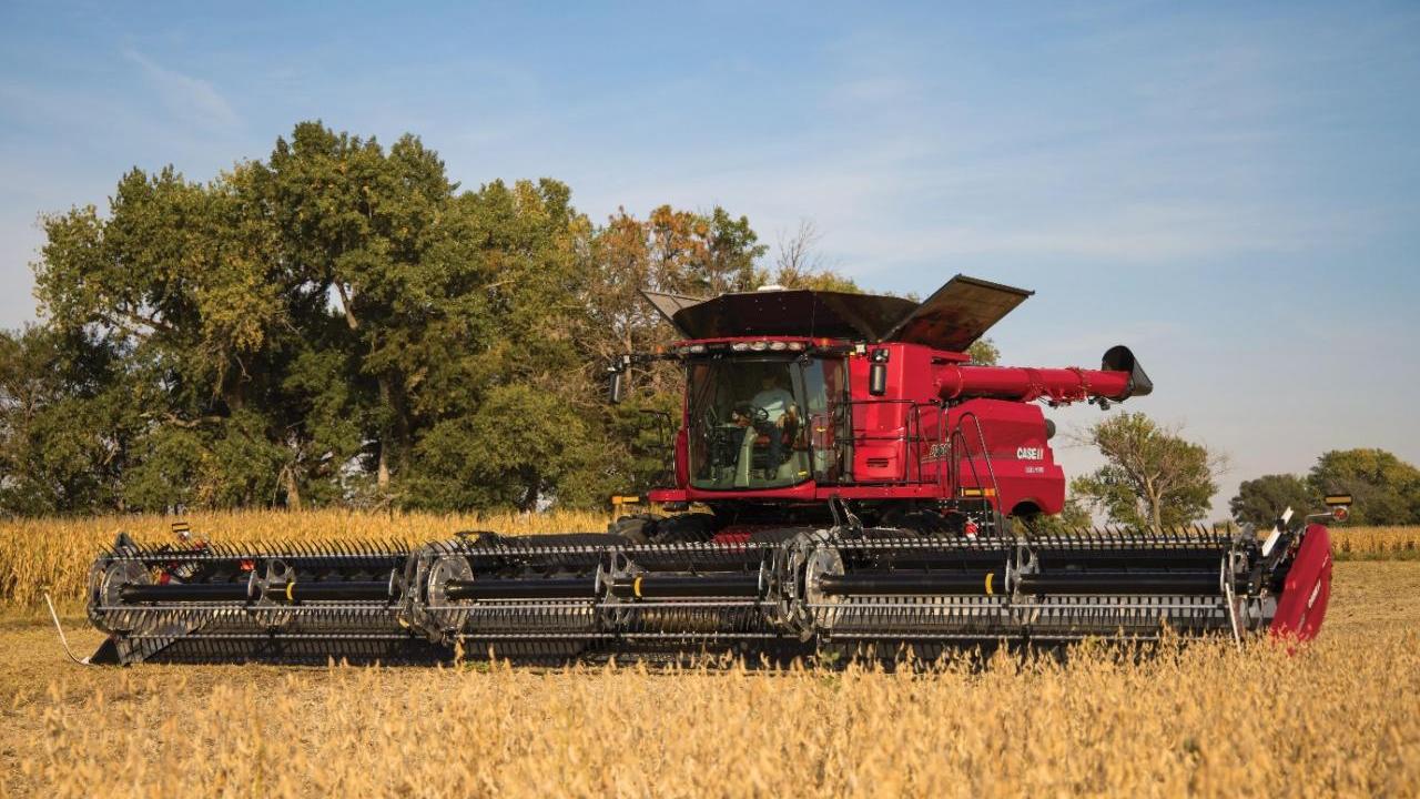 A large red farm harvester in a field