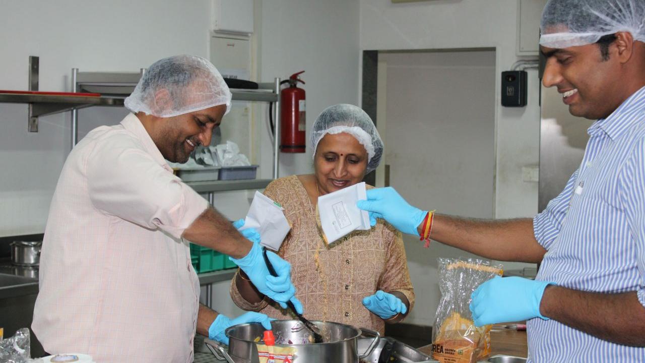 Three people cooking in a kitchen.