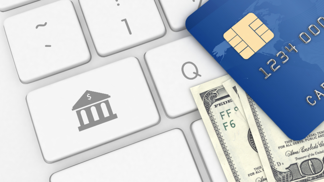 computer keyboard with credit card and paper money on top