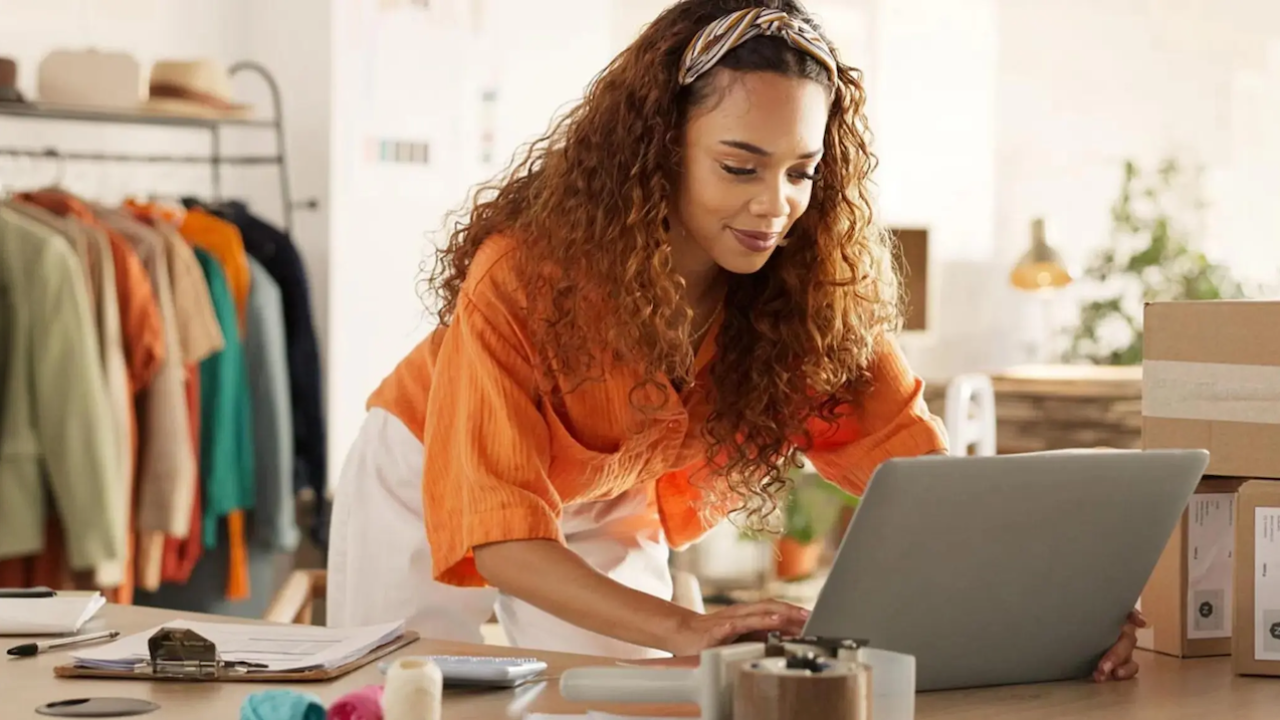 Female business owner working at her laptop in her shop.