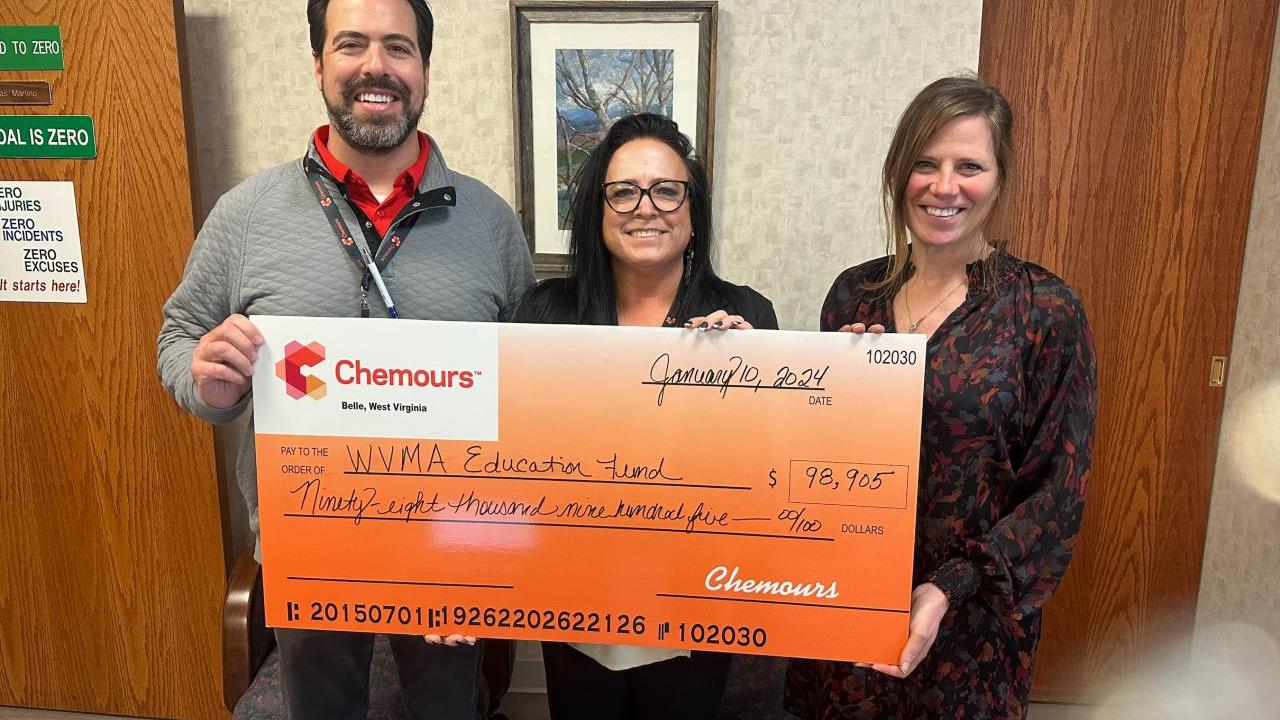 People standing together holding a large check from Chemours