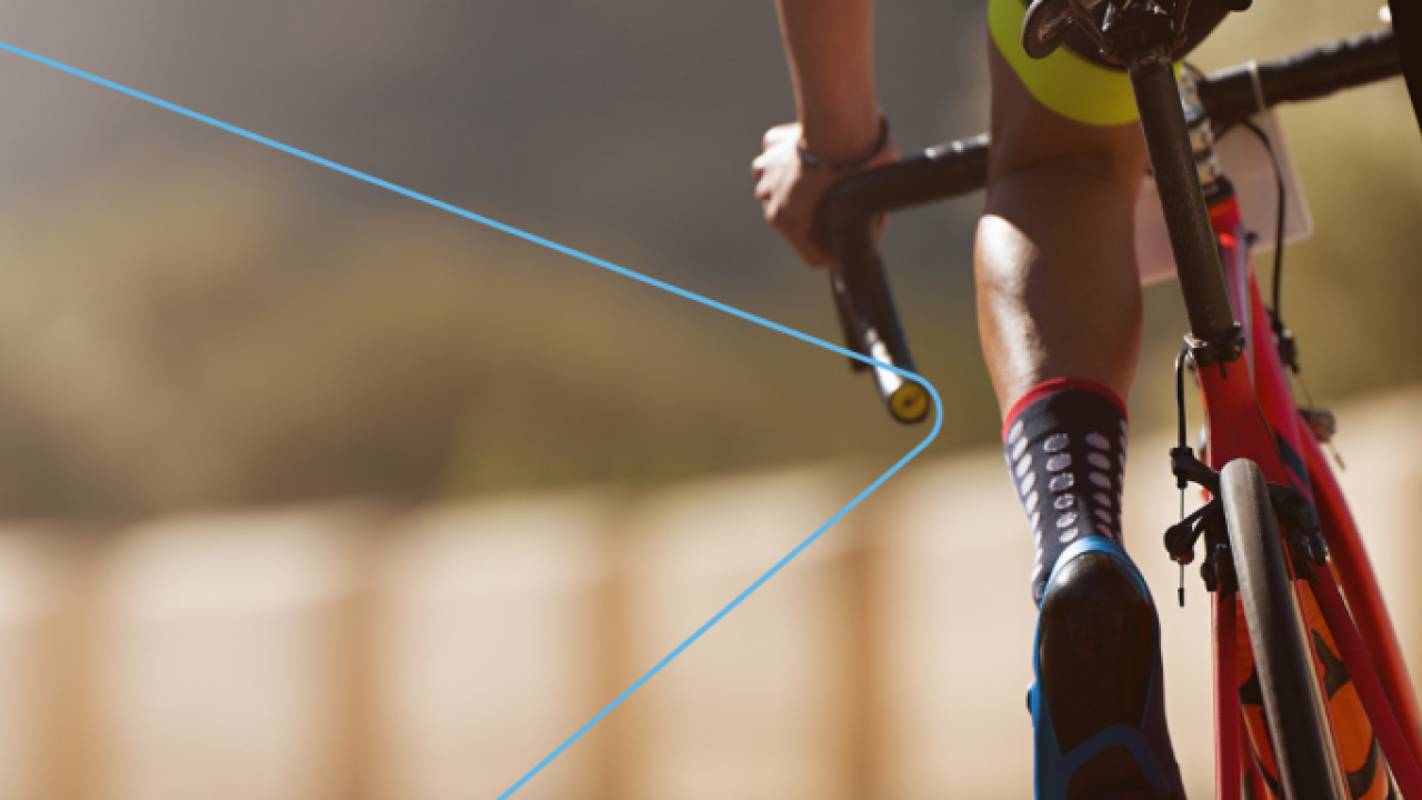 A person on a racing bicycle, riding away from the camera.
