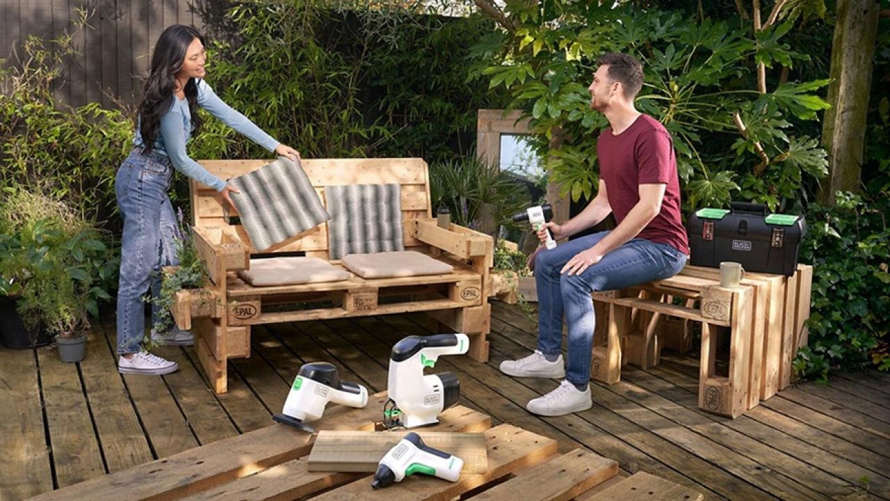 People using tools to build furniture out of wood pallets 