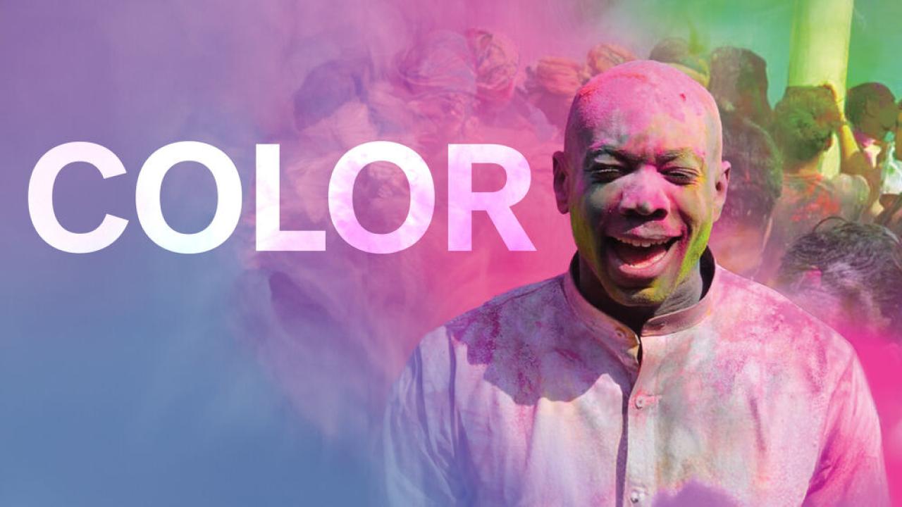 COLOR: A person in a white shirt with colored powder covering them