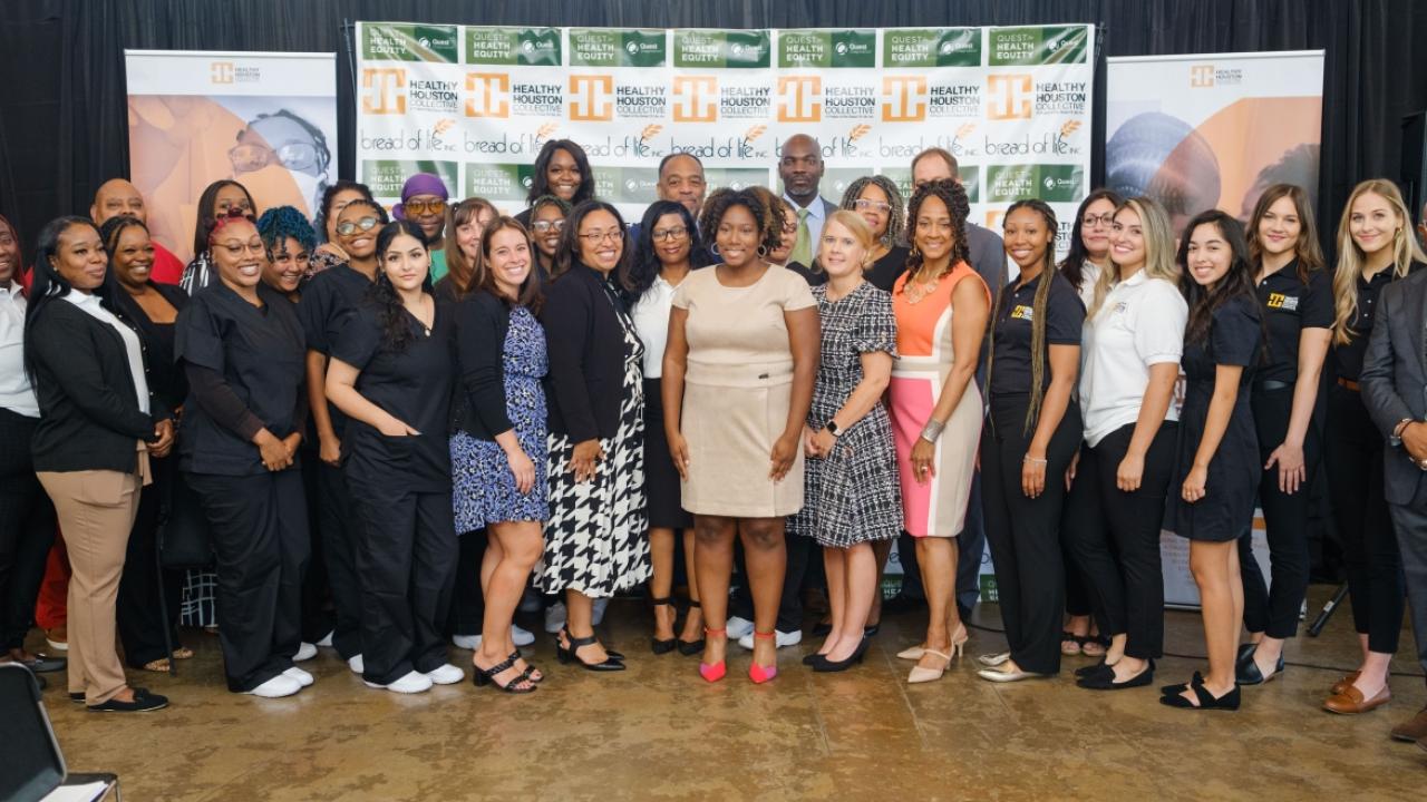 Group of people in front of a Healthy Houston Collective banner