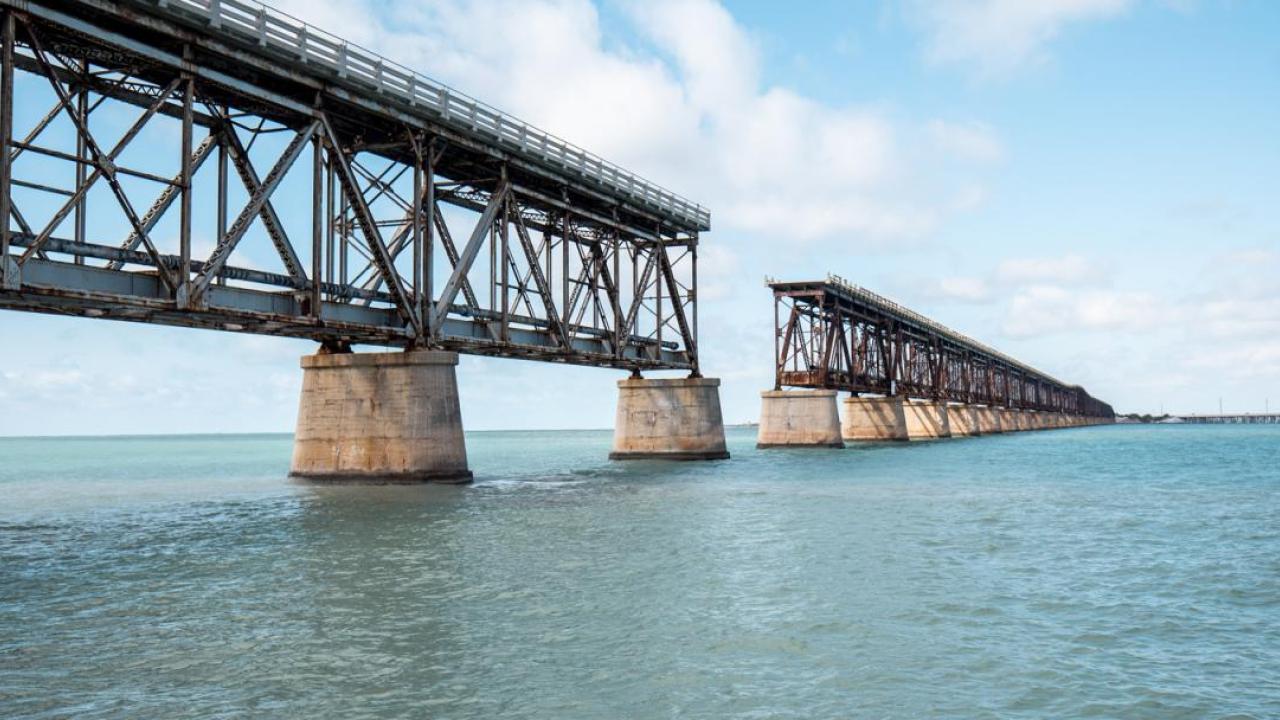 An incomplete bridge over a large body of water.
