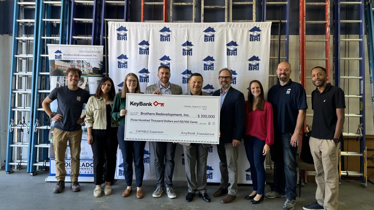 People posing with an oversized check