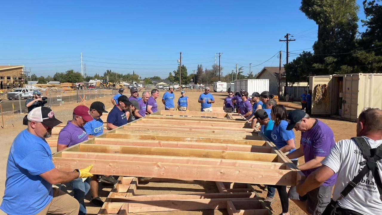 Volunteers putting up a side of a house