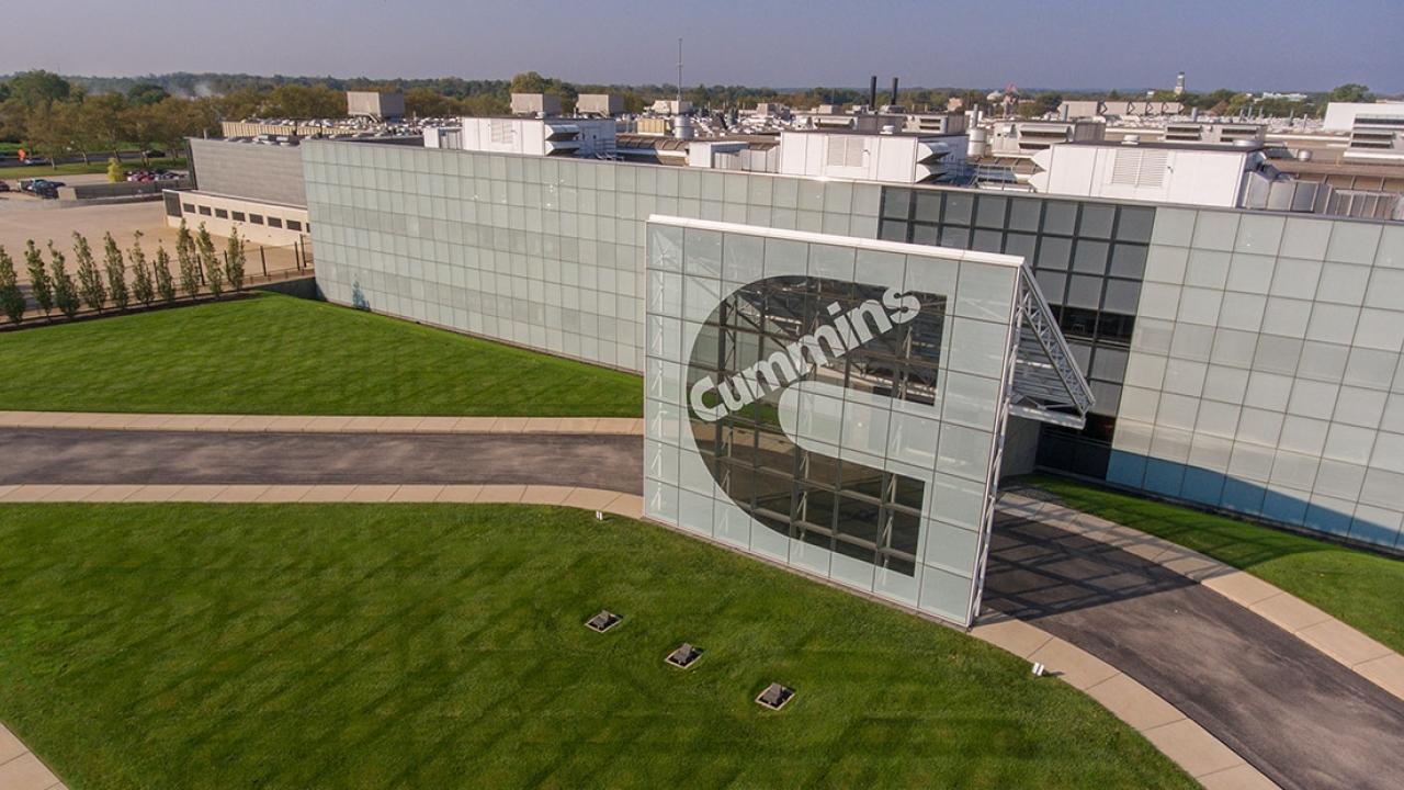 Exterior of a large building with a Cummins sign in front.