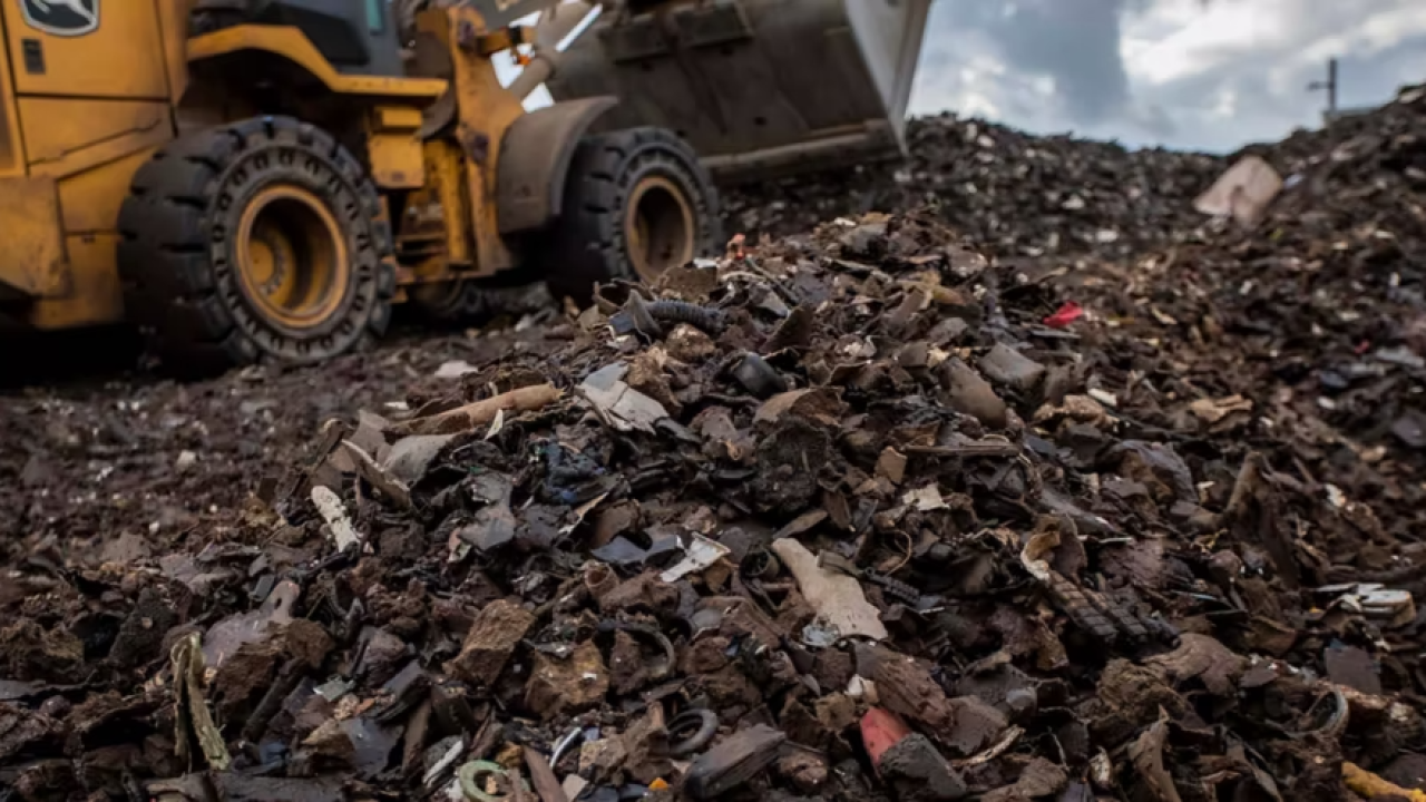 Bulldozer scoops up automotive waste