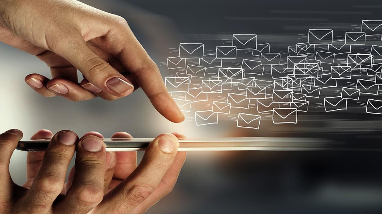 Reflection of someone using a mobile phone with envelope illustrations 
