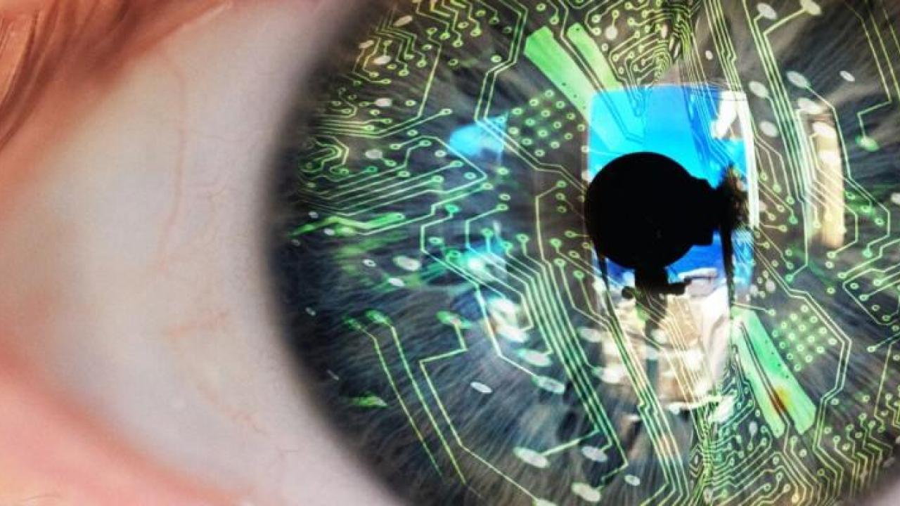 Close up of an eye. The iris overlaid with circuit board graphics.