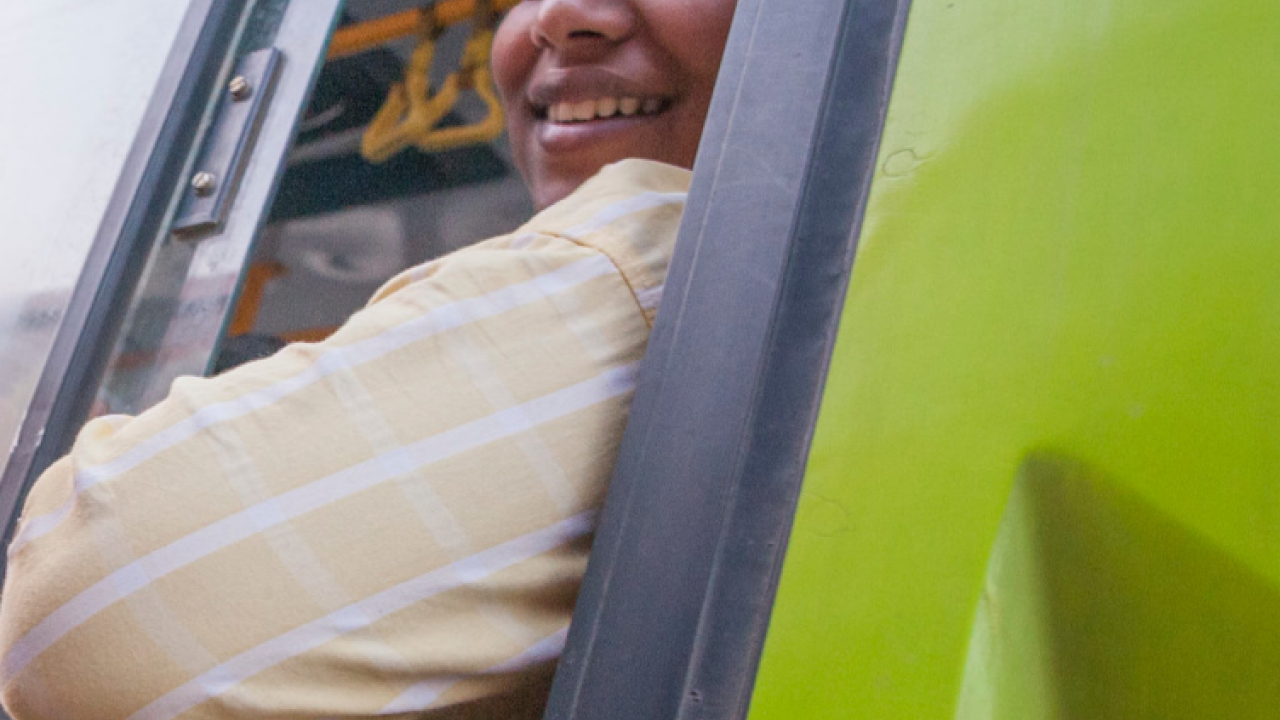 a rider leaning out of a bus window