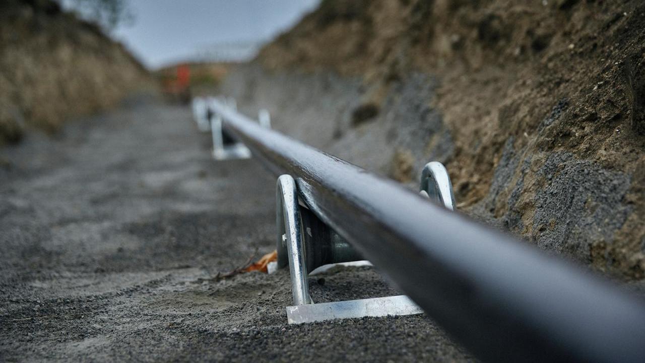 A long cable in a trench in the ground.