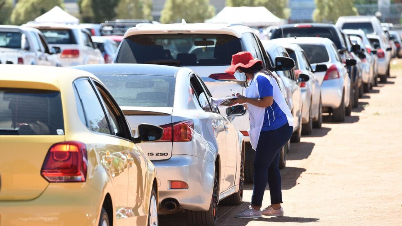 cars parked with person speaking to people in cars