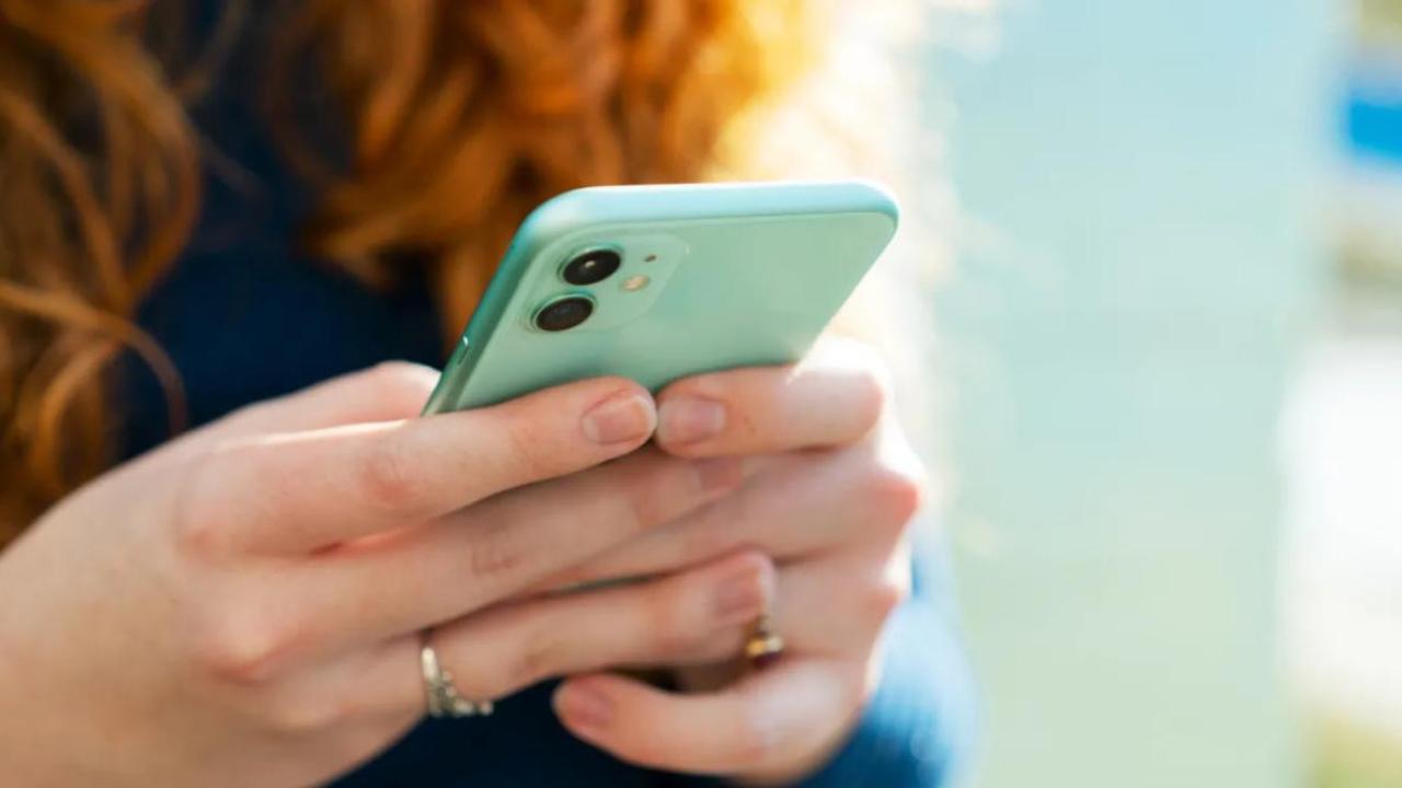 A person using a cellular device with both hands.