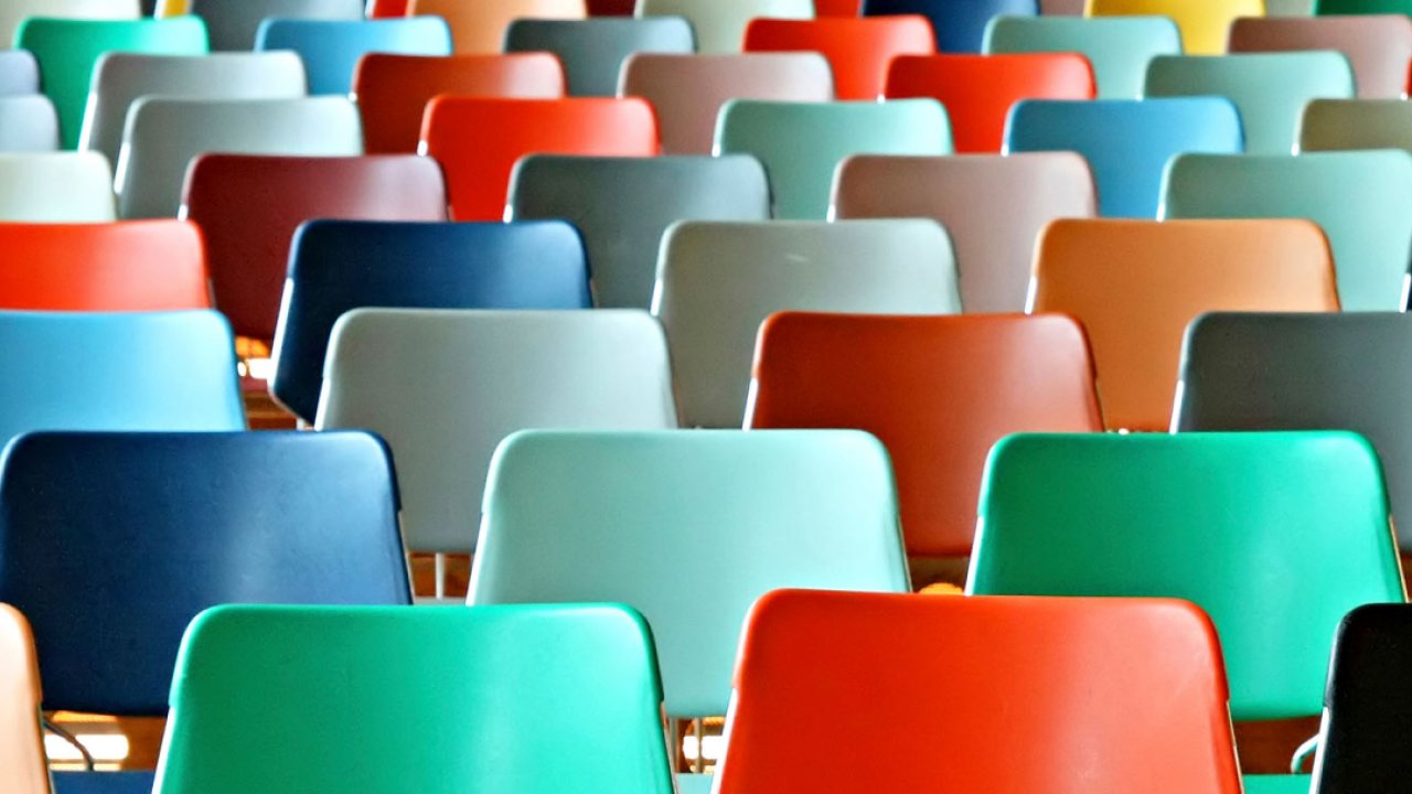Rows of colorful empty chairs.