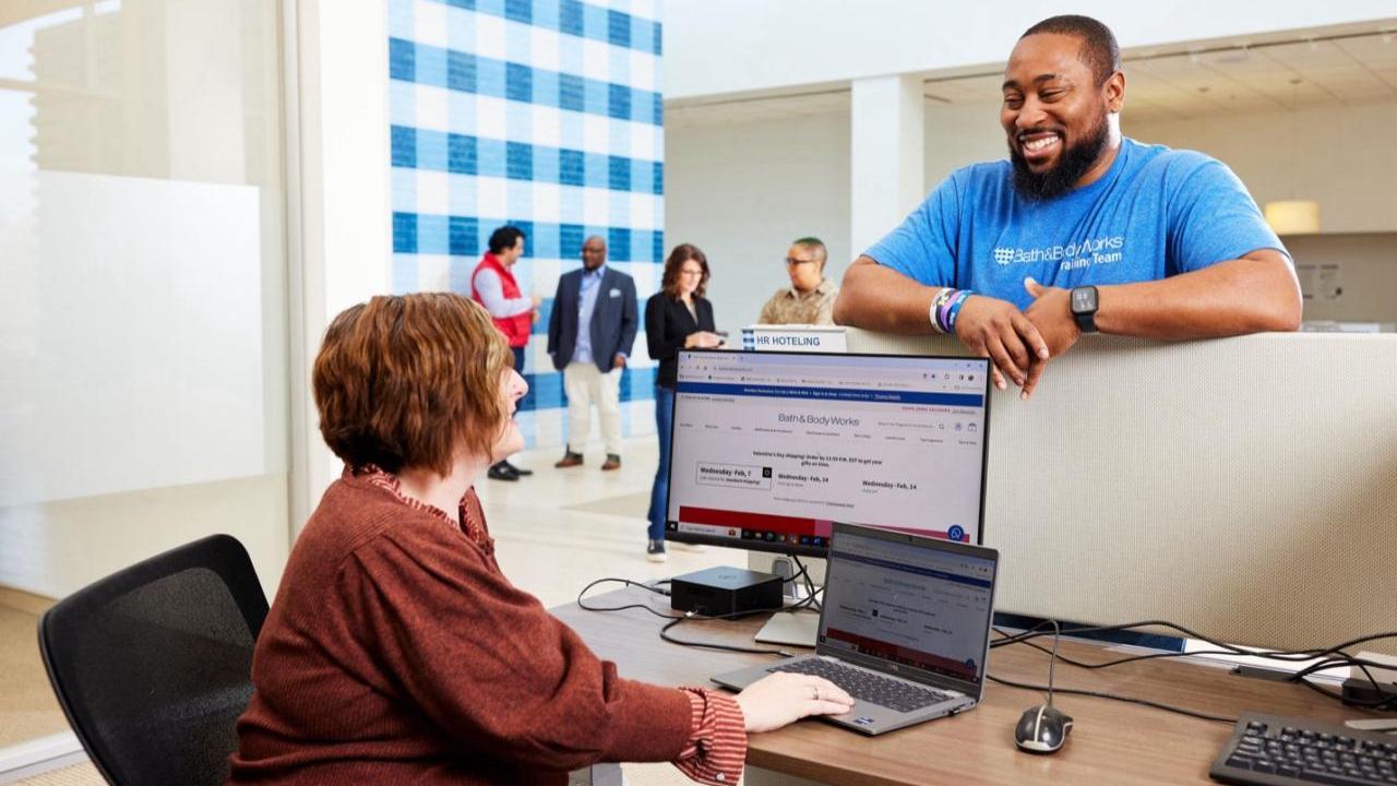 2 employees chat at a desk