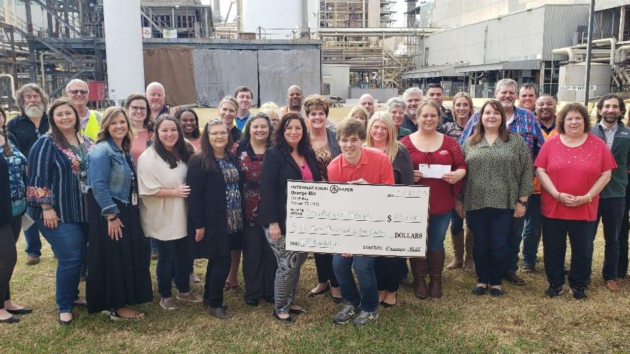 Group of people with a big check from International Paper 