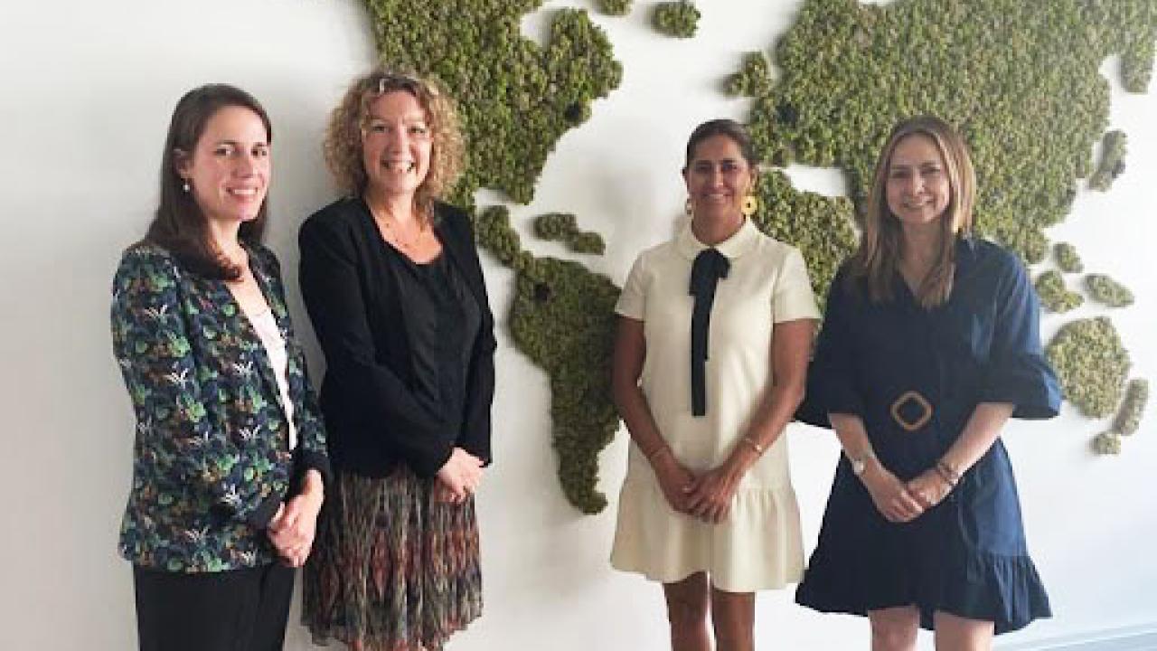 4 women in front of a map of the world
