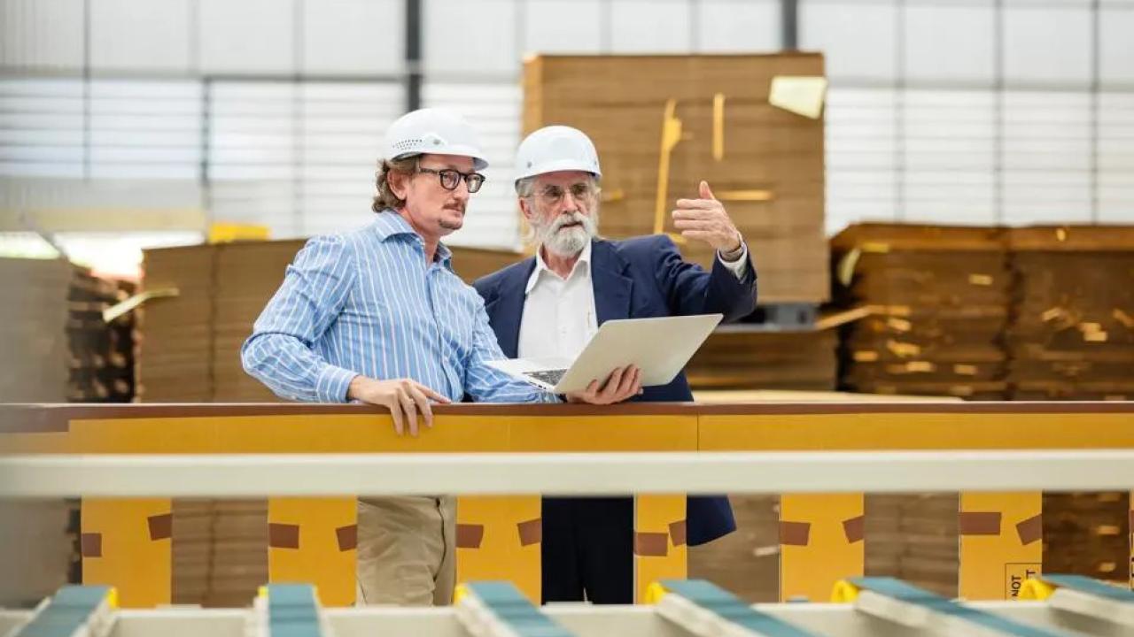 Two people in hard hats in a manufacturing scene.
