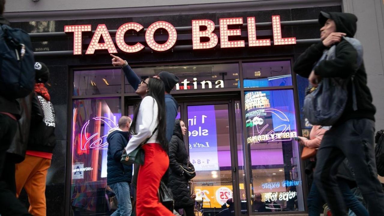 People walking by a Taco Bell
