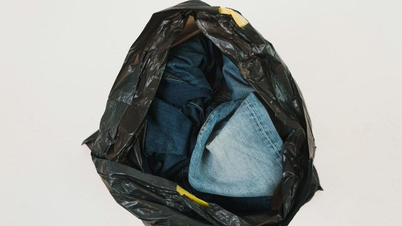 A black garbage bag with jeans inside