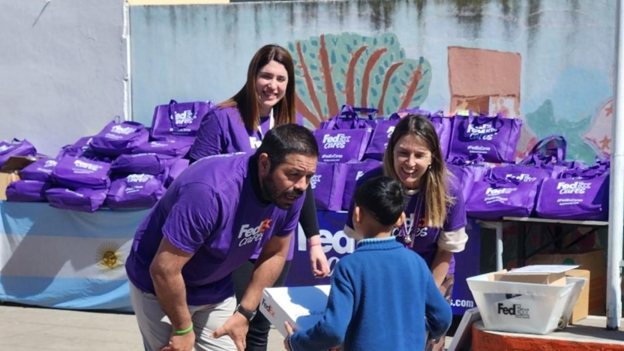 Volunteers handing a box to a child