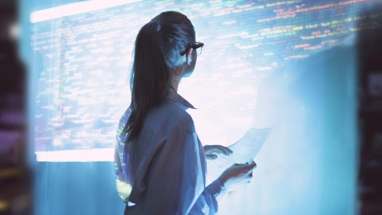 Woman looking at a wall of computer code