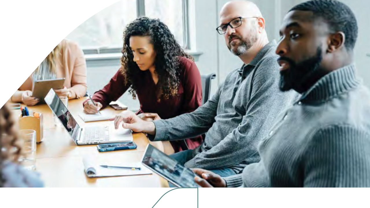 workers with laptops at a conference table