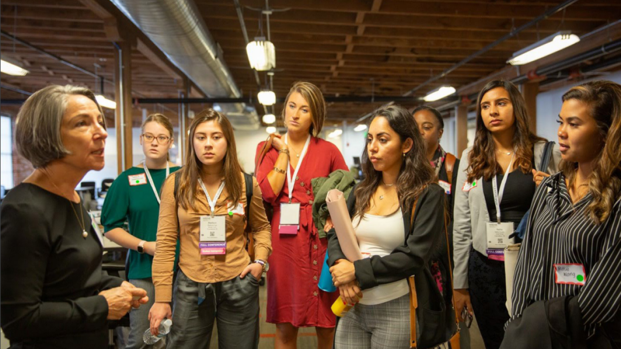 A woman talking to a group of women that are part of the 2019 Collegiate Accelerator program