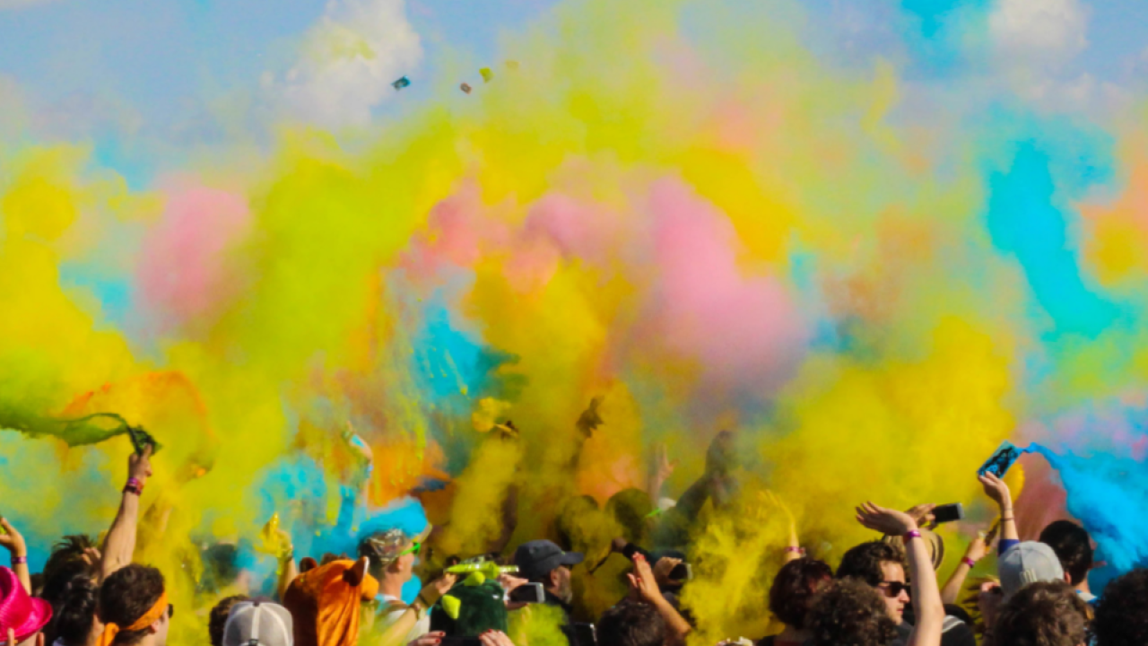 a large group of people a cloud of different colored chalk dust above them