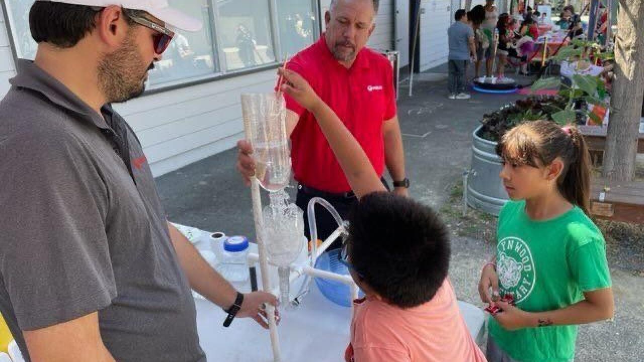 An employee showing attendees a display.