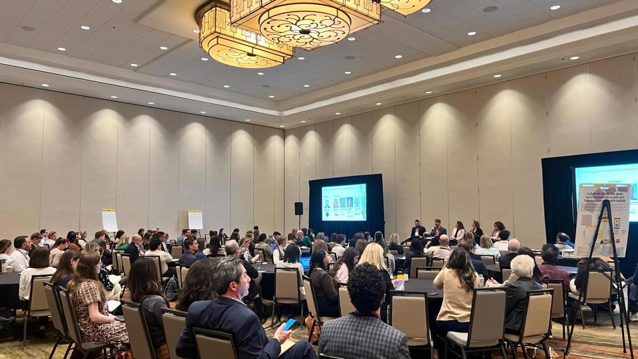 Conference room filled with people at tables and chairs