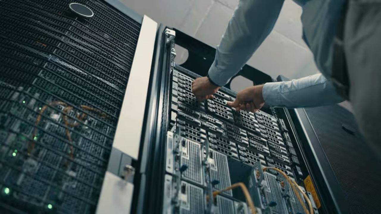 Technician installing server components inside a data center, supporting cloud computing and AI infrastructure.