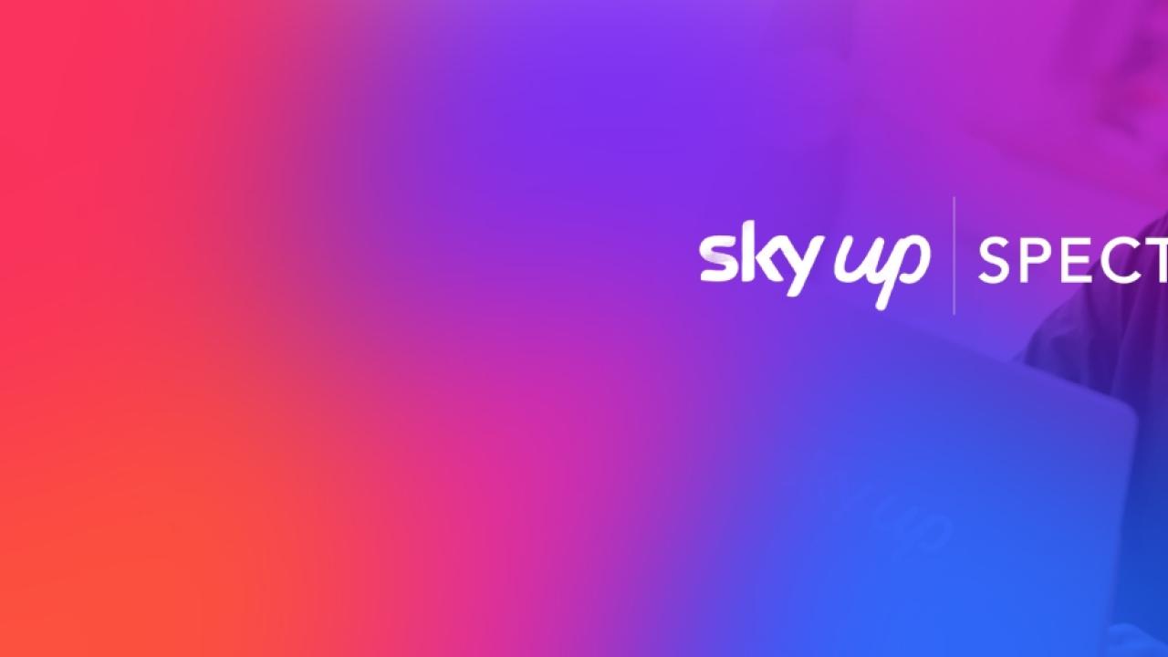 Photo of person on a laptop with colorful overlay and text: sky up, Spectra