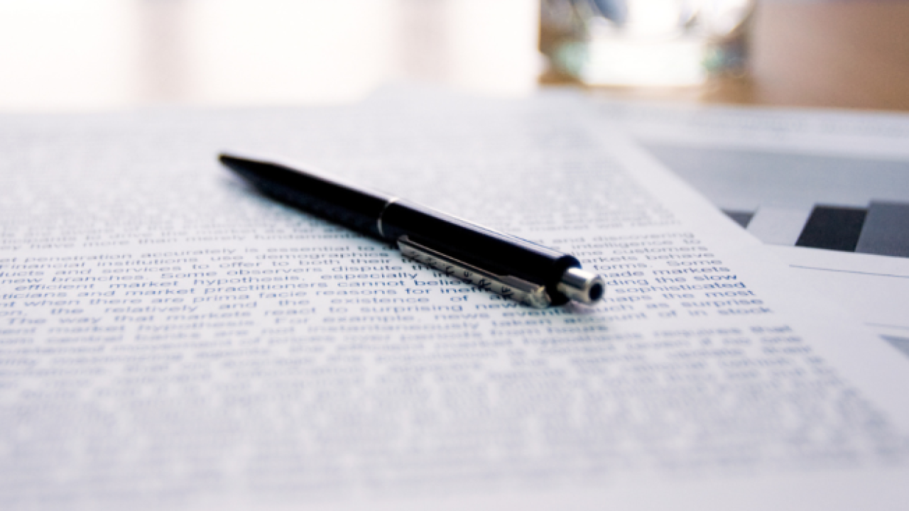 pen on stack of papers