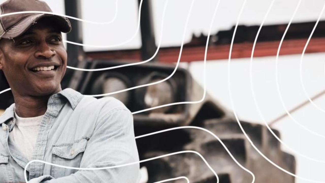 A person outside in front of a tractor.