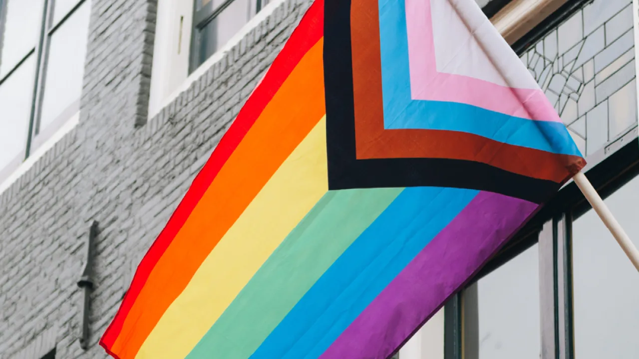 LGBTQ flag flying on a building