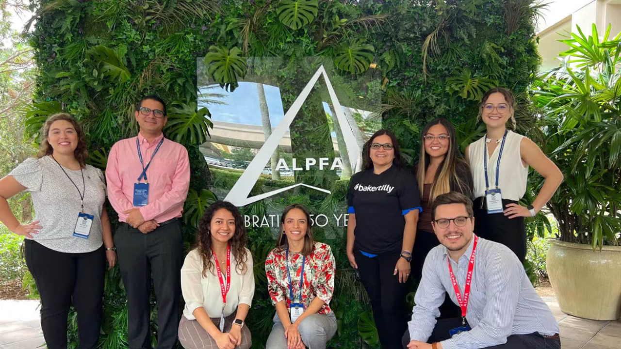 A team posed in front of a ALPFA sign outside.