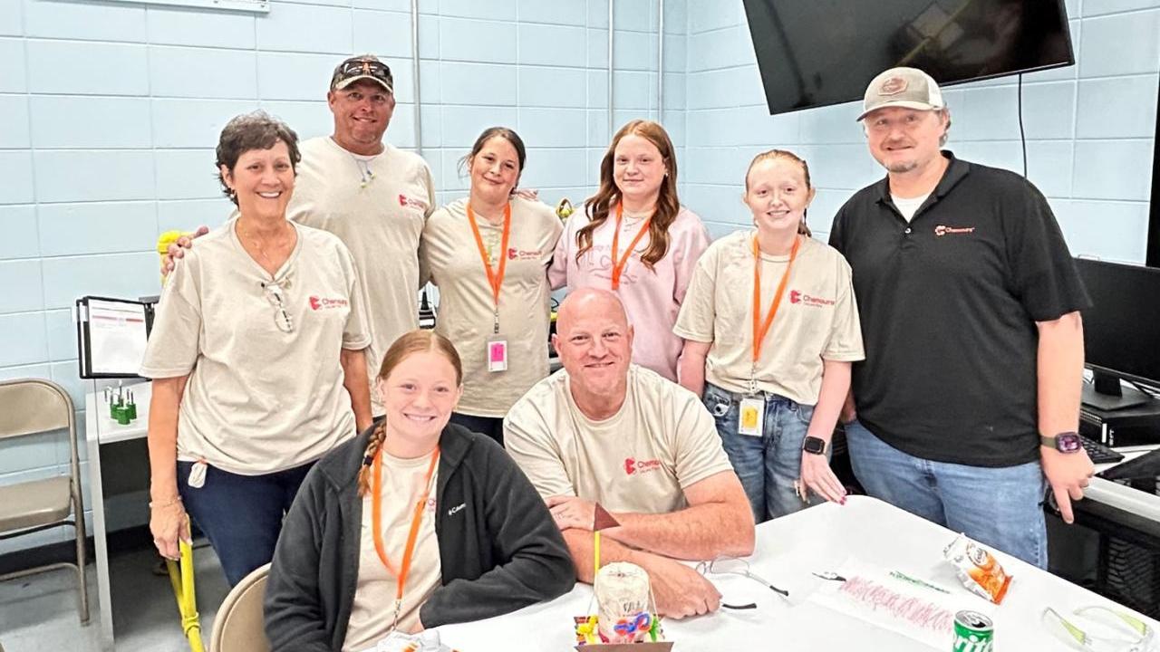 A group of 8 people posing in a cafeteria