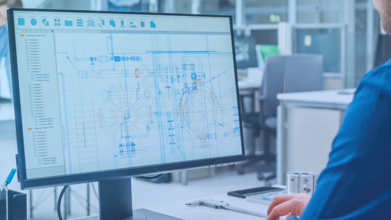 A person looking at a complicated blueprint on a computer screen.